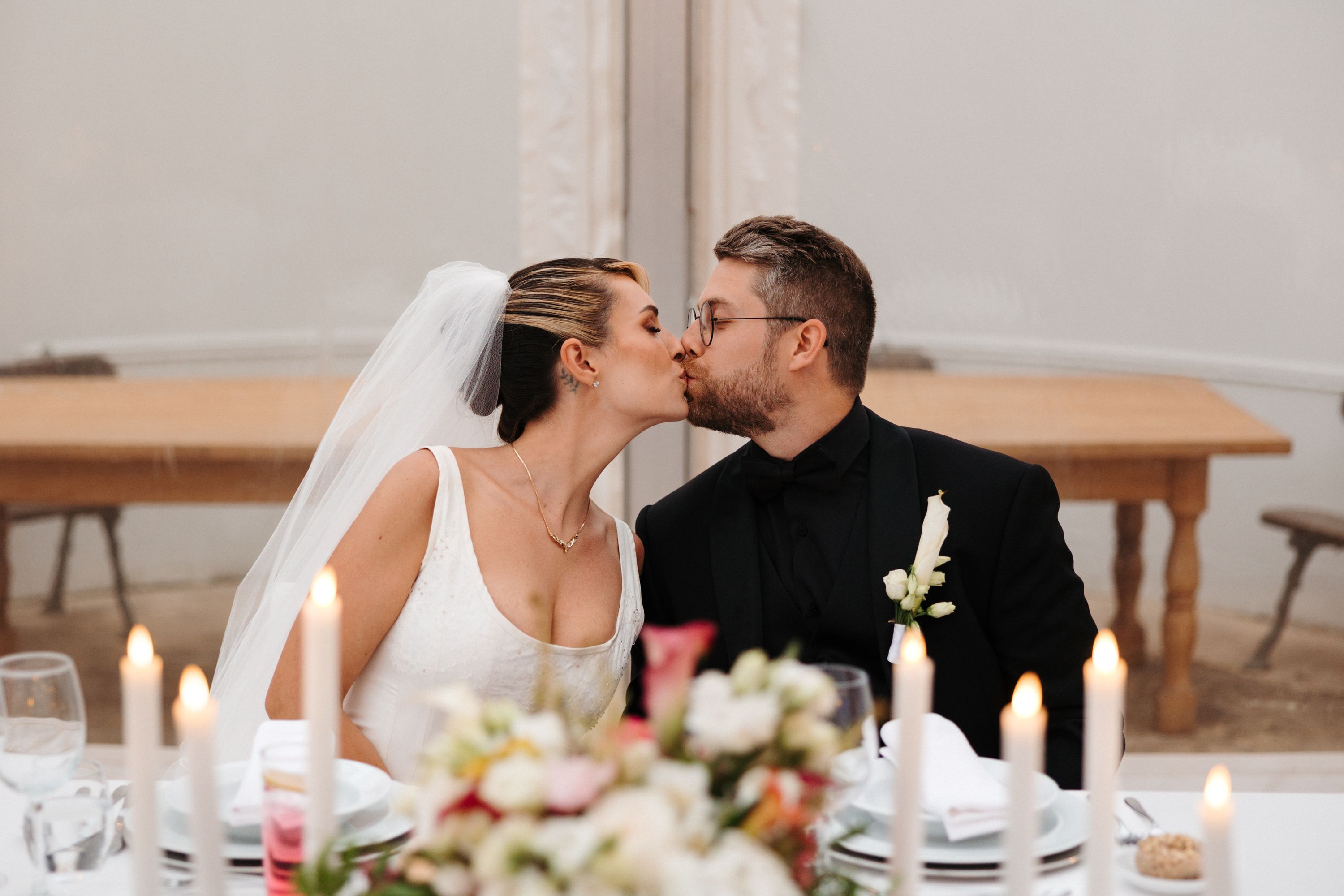 Bride and groom kissing while seated during their destination wedding in Spain