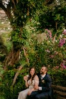 Newlyweds laughing during the photoshoot of their elopement in Italy, with lush greens in the background
