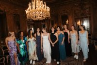 Bride in a wedding dress with her bridesmaids inside a palace room with exquisite chandelier in Portugal