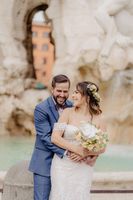 Newlyweds enjoying a photoshoot at the Trevi Fountain in Rome after the ceremony of their winter destination wedding in Italy