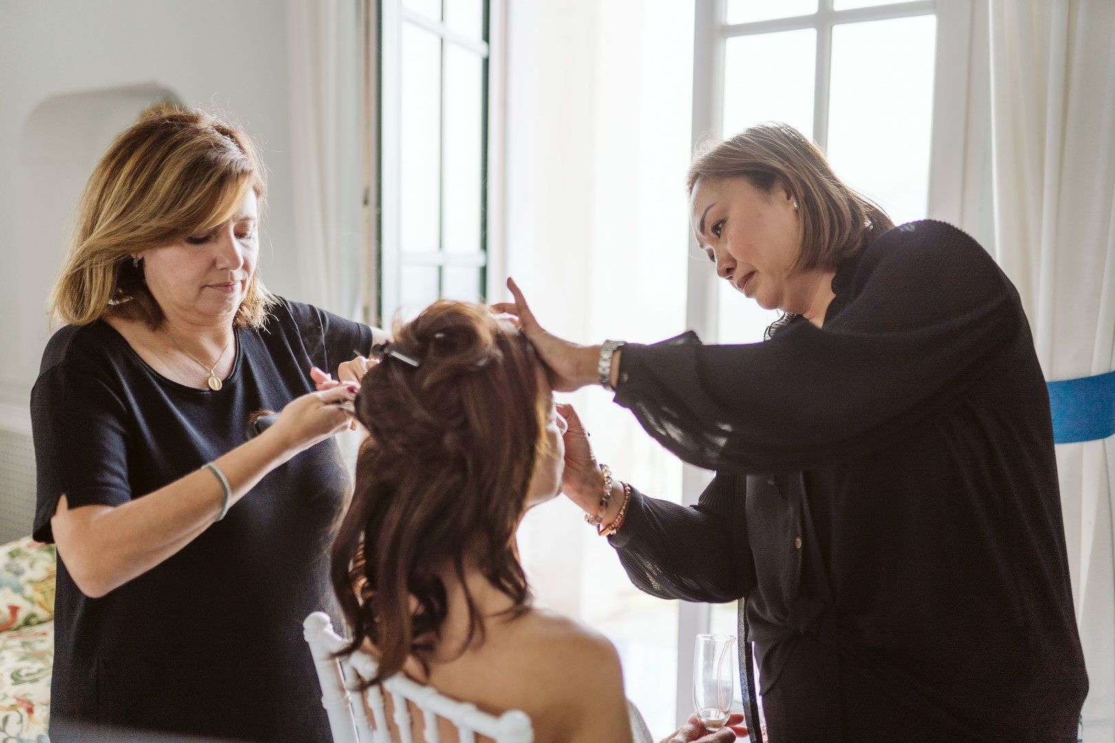 Bride getting her makeup done for her destination wedding in Italy, with two makeup artists with her