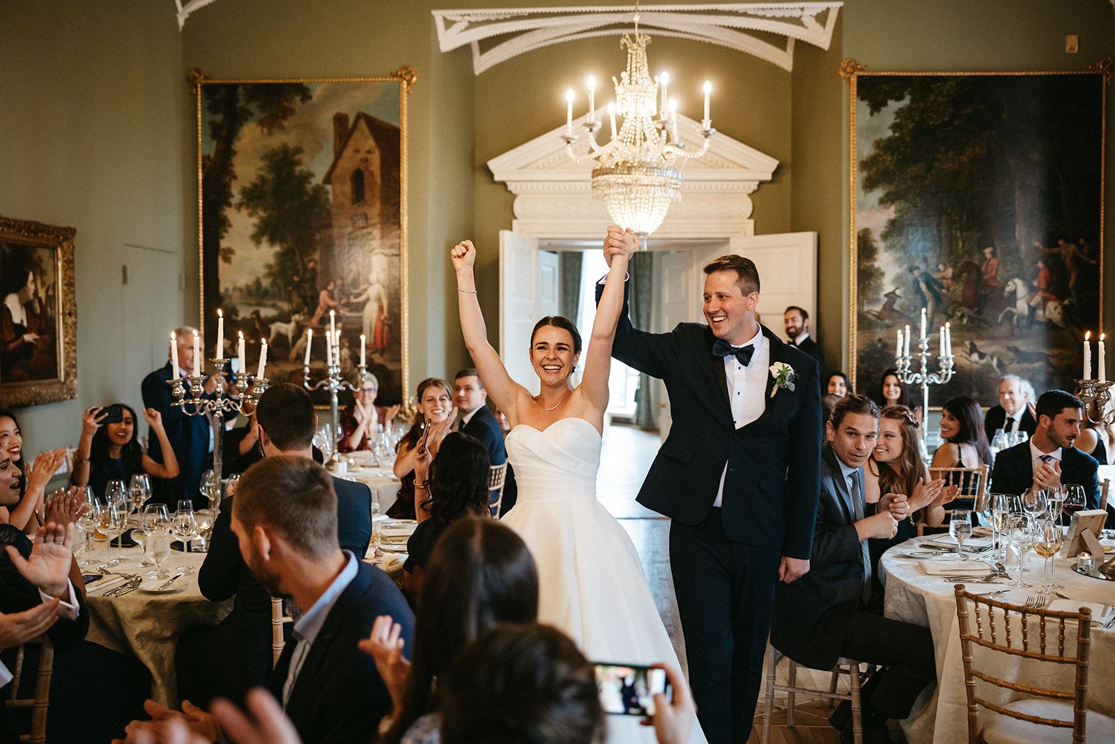 Bride and groom raise hand in celebration during the reception of their small wedding in Ireland