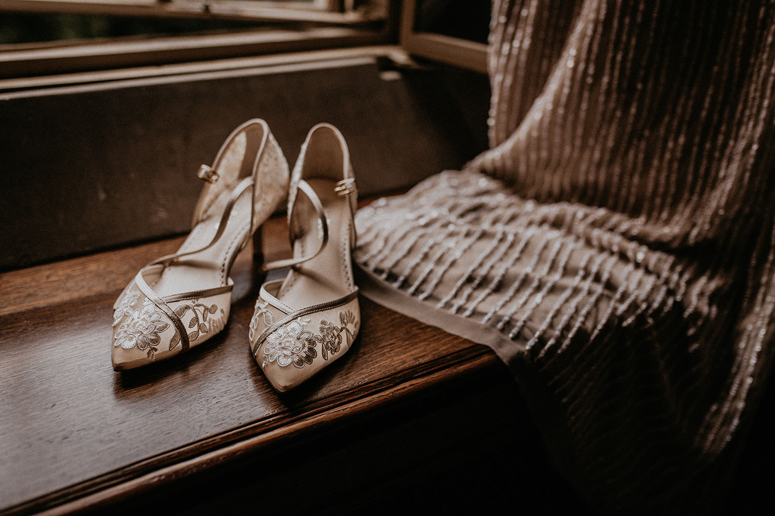 Embroidered bridal heels beside a shimmering dress detail at an intimate wedding in Portugal
