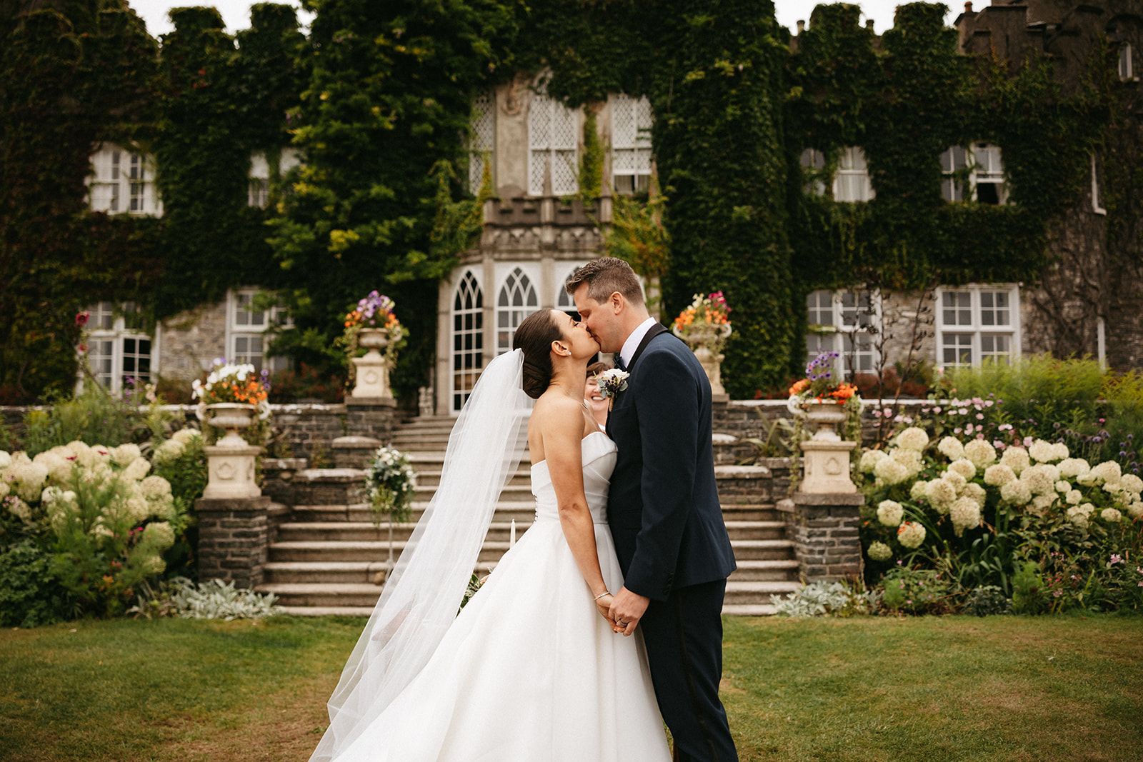 Newlyweds kiss in front of an iconic castle for micro weddings in Ireland
