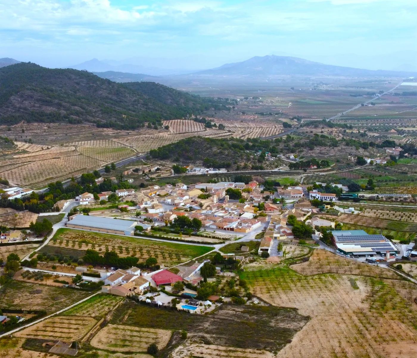 A drone shot of Valencia, Spain’s landscape dotted with forests, medieval houses, and vineyards