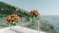 Floral arrangement of orange shades serve as decor atop a terrace of a hotel in Sorrento for an Italian small wedding