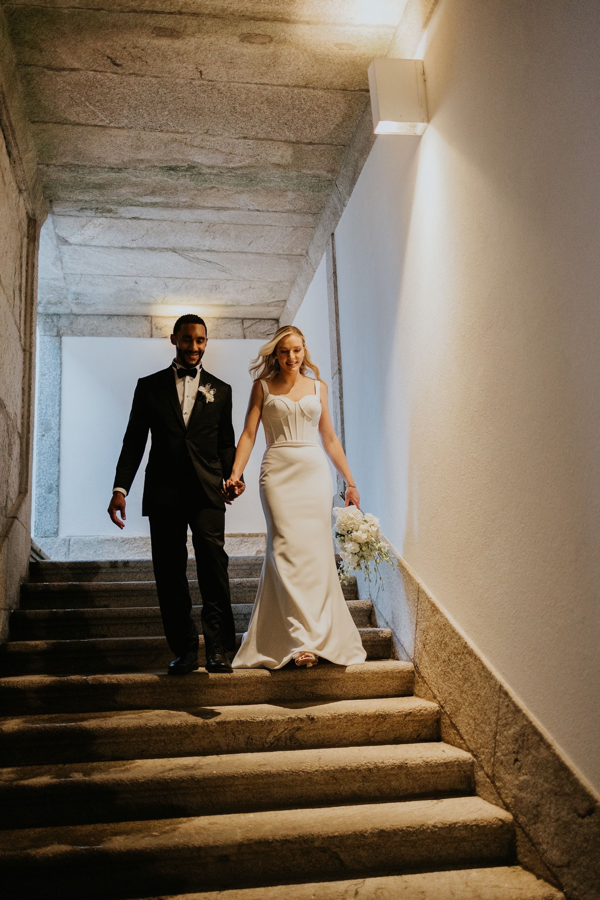 Newlyweds hold hands as they walked down the stairs during the photoshoot of their small wedding in Portugal