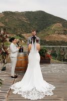 Couple holds hands during the ceremony of their micro wedding in Portugal with mountains and vineyards in the background