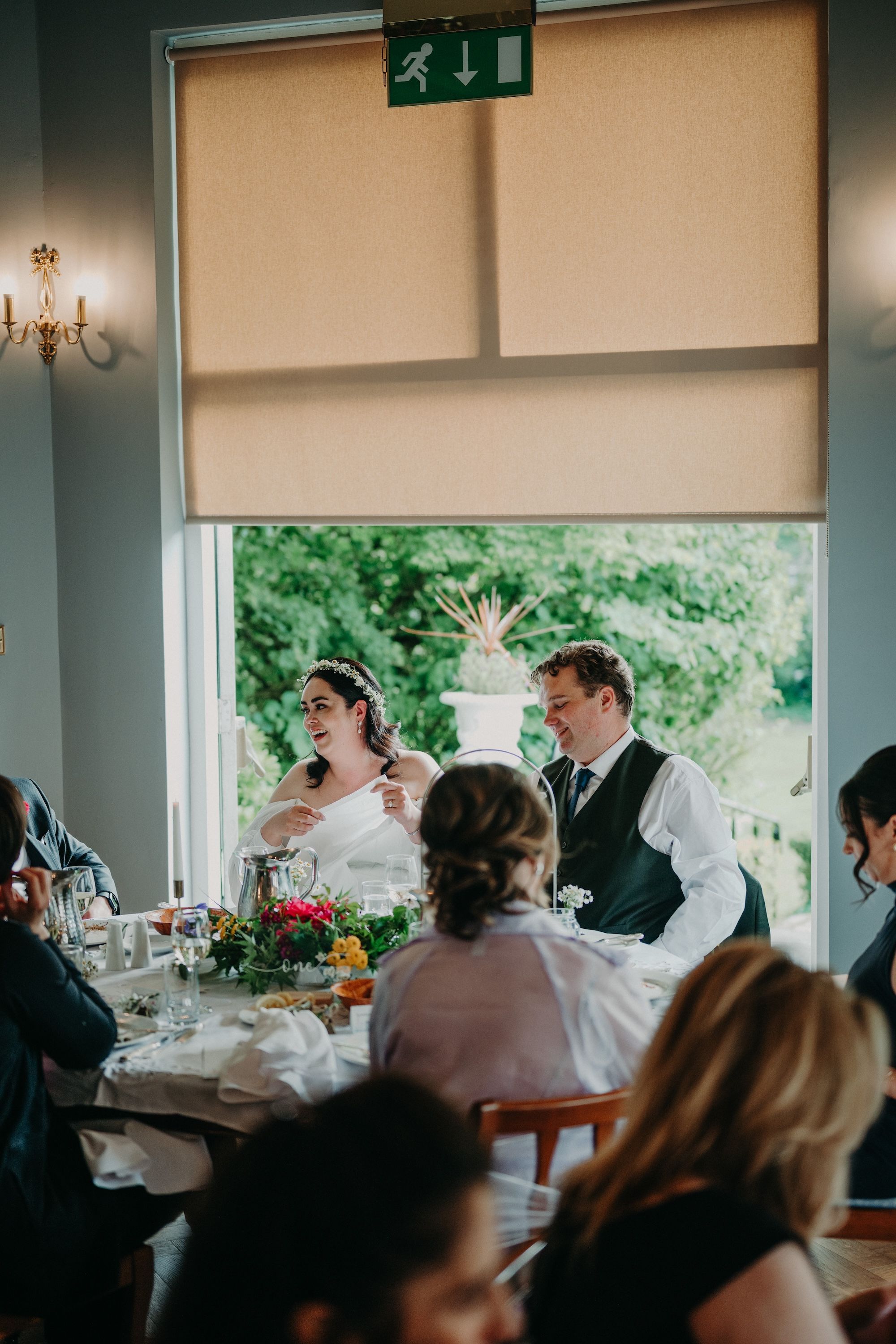 Bride and groom with their guests in a hotel event room during the reception of their micro wedding in Ireland