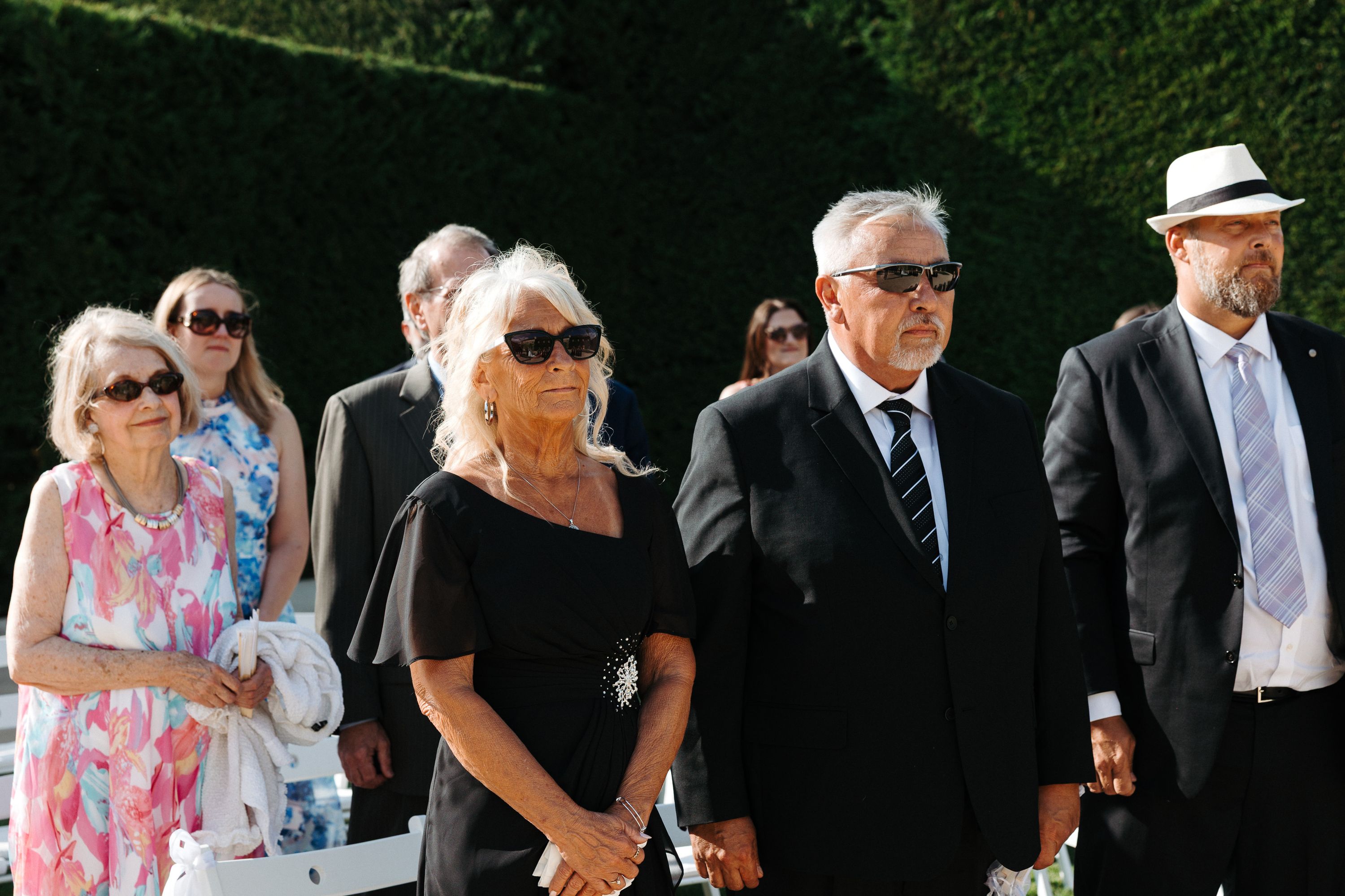 Family members watching the ceremony during a small wedding in Portugal in a lush garden venue