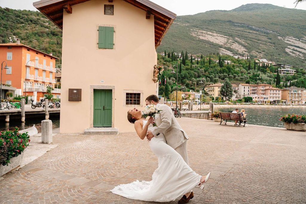 Couple laughing during their elopement in Italy at a castle along Lake Garda with Italian rolling hills in the background