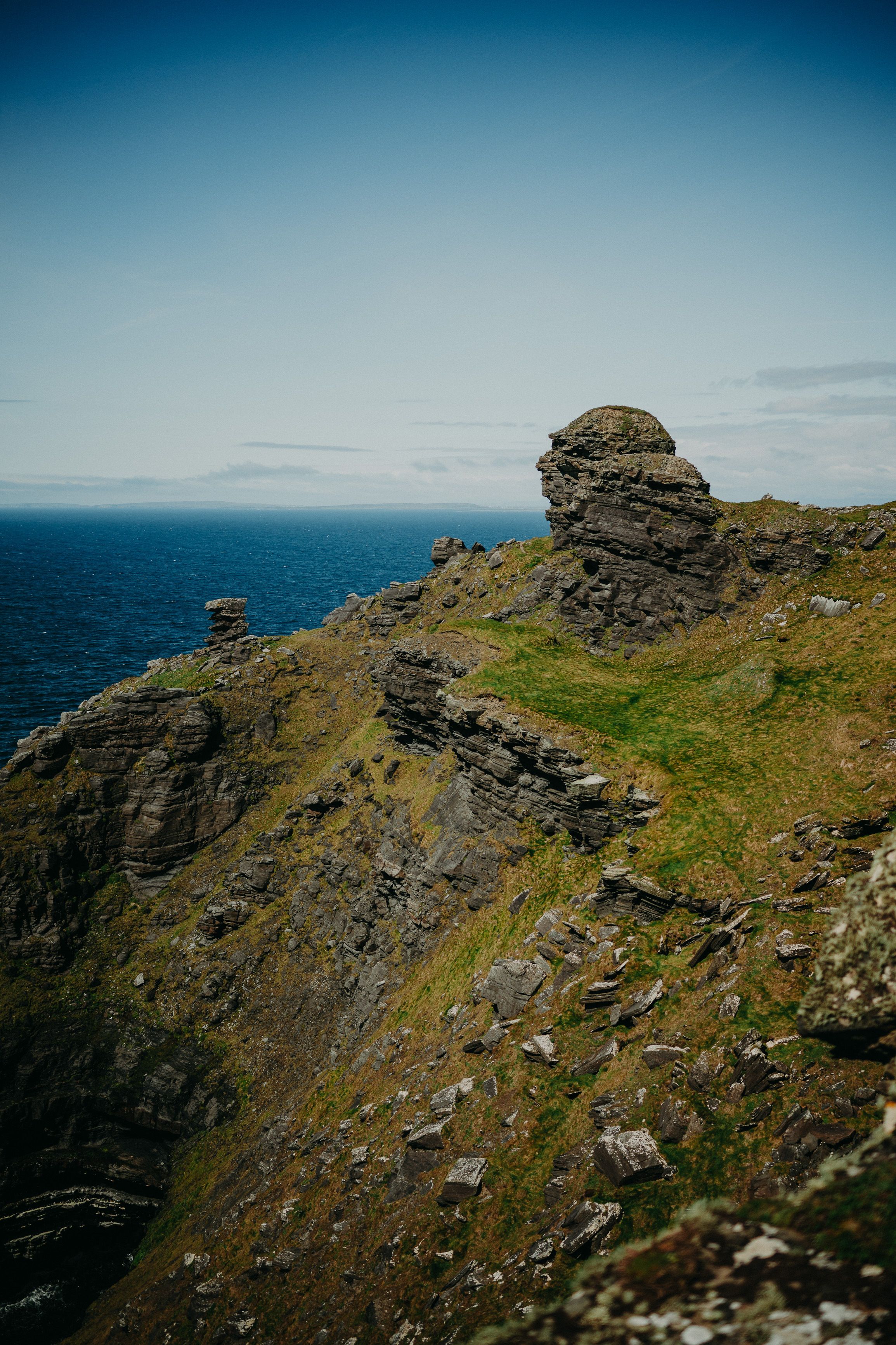 A cliff filled with rocks, grass, and a stunning view of the ocean for an intimate wedding in Ireland