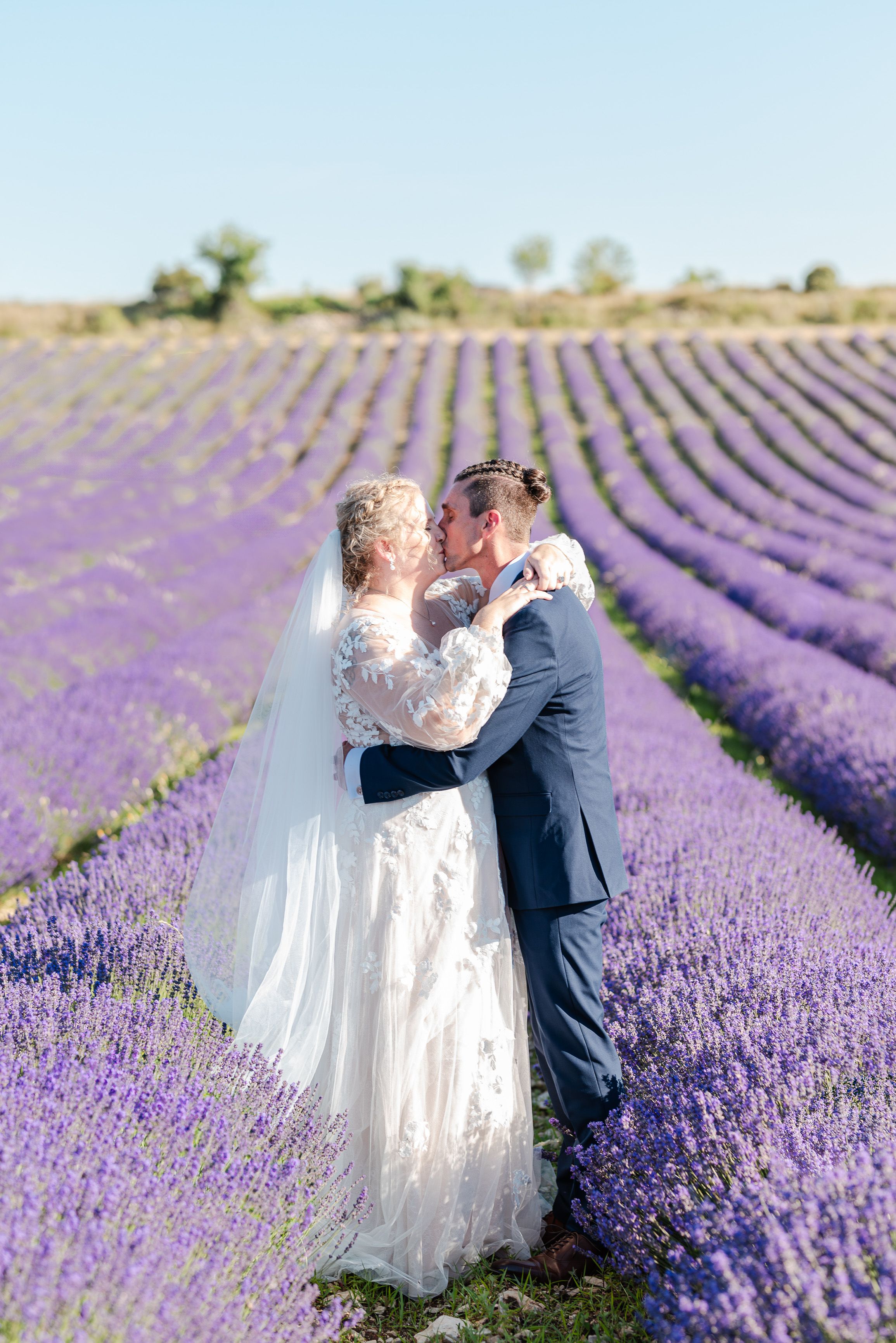Bride and groom kissing in a lavender field during a small wedding in France