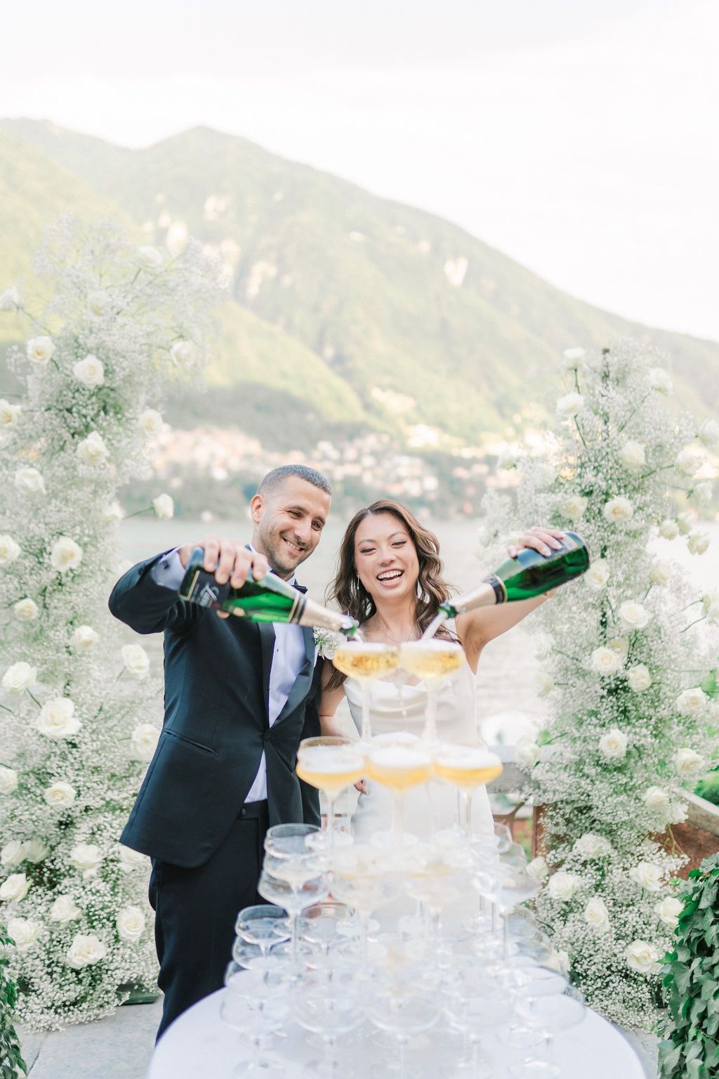 Bride and groom pouring a champagne tower at their intimate destination wedding in Italy