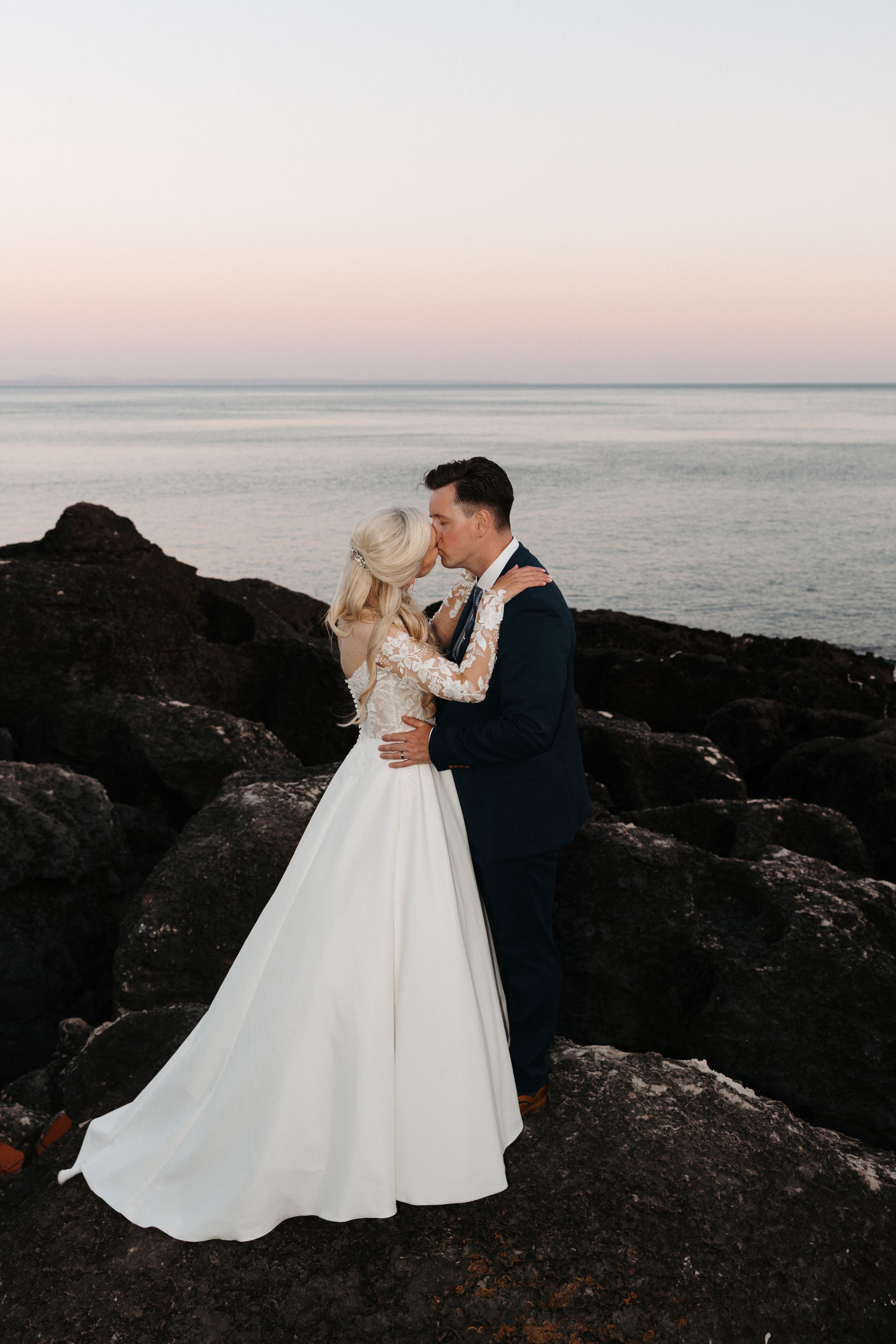 Newlyweds kissing with the Estoril coast in the background during their micro wedding in Portugal