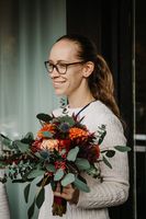 Destination wedding planner in Germany, Austria and Switzerland holding a bride's bouquet and smiling