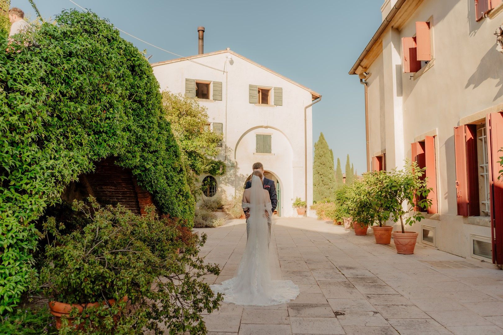 Bride and groom in the middle of an estate of a villa in Tuscany during their destination wedding in Italy