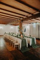 Two long tables with candles, white and green cloth, arranged in an Irish pub for the reception of a small wedding in Ireland