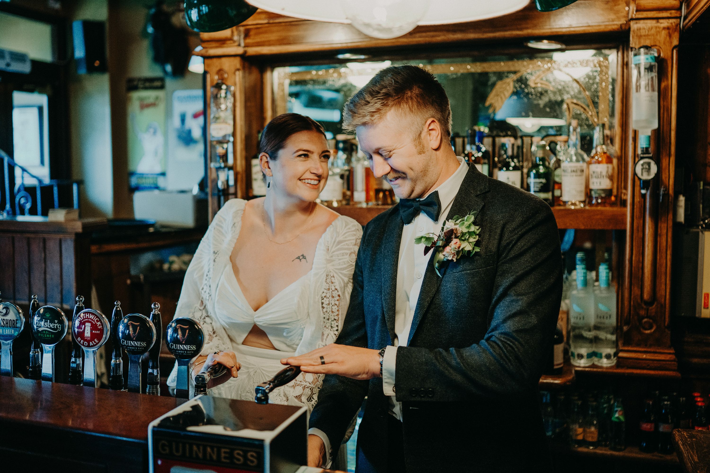 A bride and groom pouring drinks during a reception party after their intimate wedding in Ireland