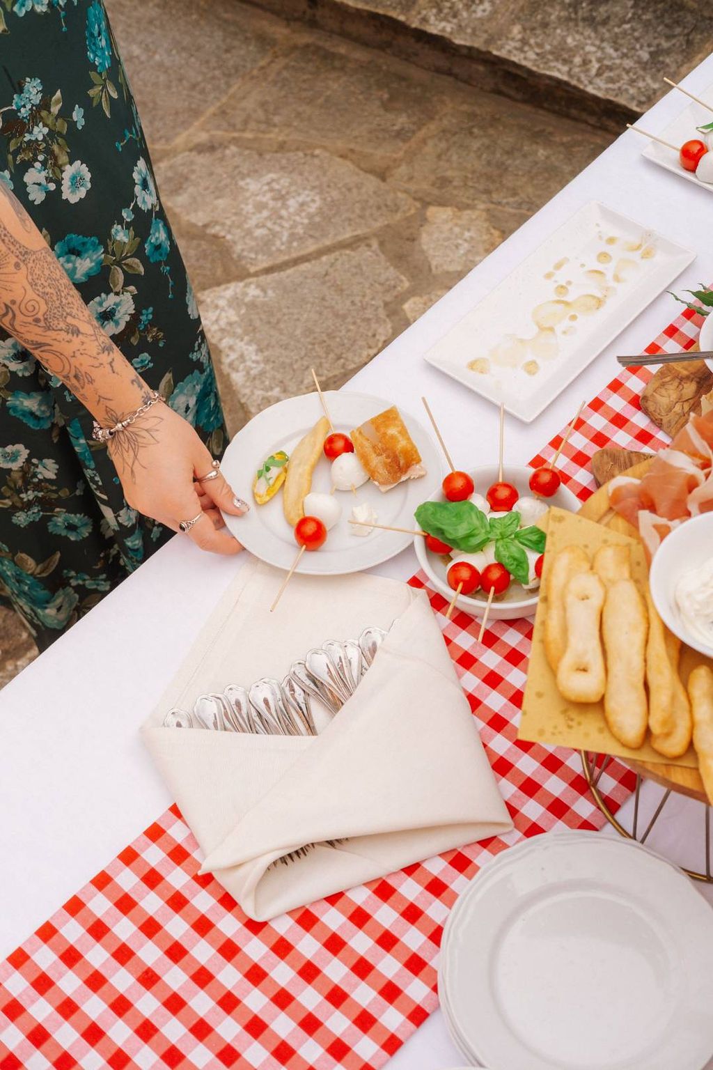 Cherry tomatoes, white cheese balls, and other aperitifs for a drinks reception of a small wedding in Italy