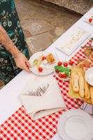 Cherry tomatoes, white cheese balls, and other aperitifs for a drinks reception of a small wedding in Italy