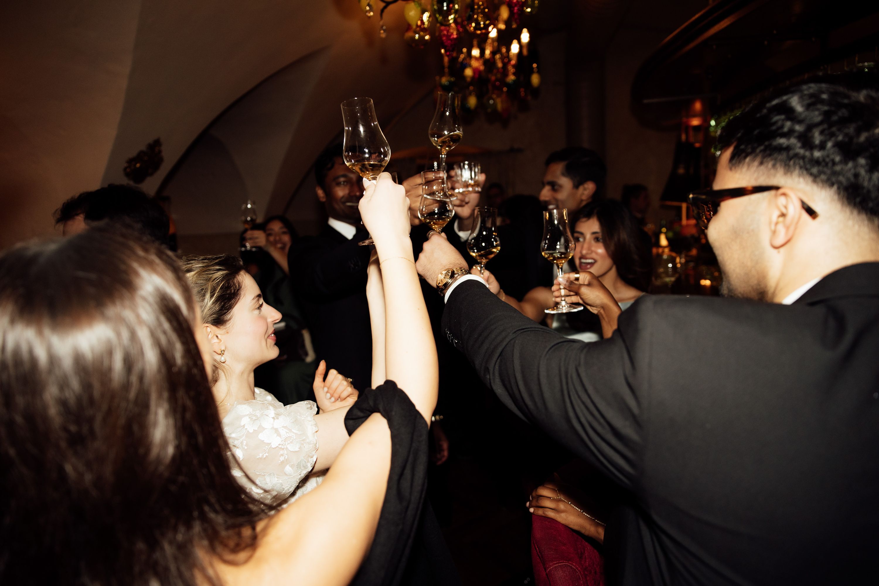 Couple raise drinks and smile during a reception celebration at an intimate wedding in Austria
