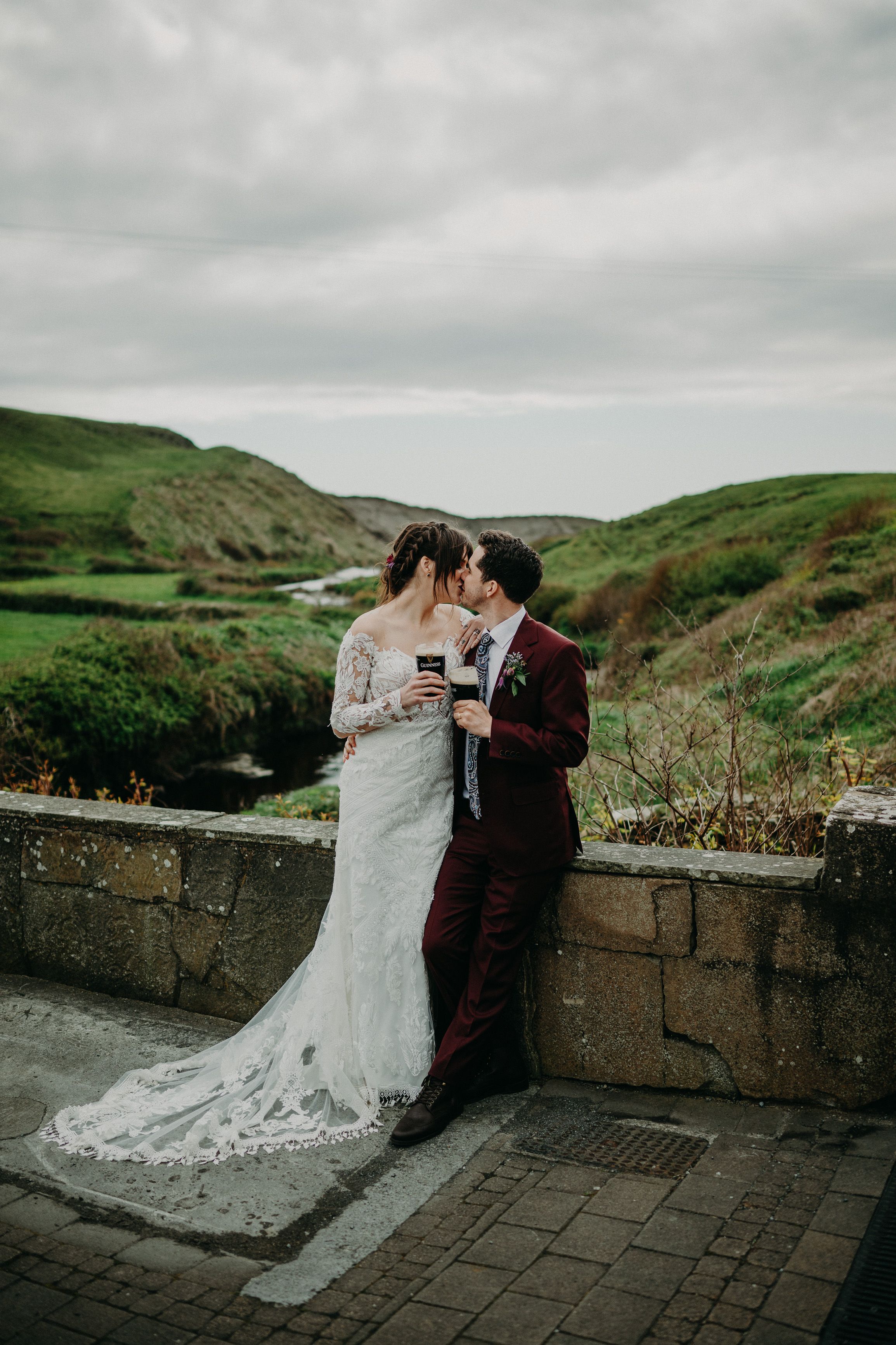 A bride and groom having a drink with a beautiful view of the mountain after their small wedding in Ireland