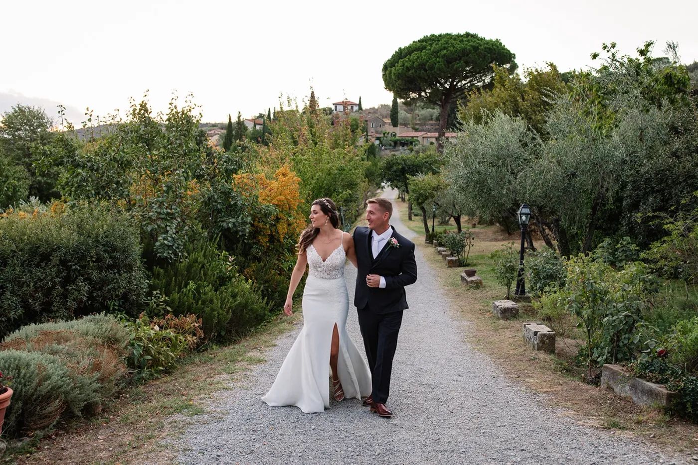 Newlyweds walking in the middle of a vineyard in Tuscany after the ceremony of their destination wedding in Italy