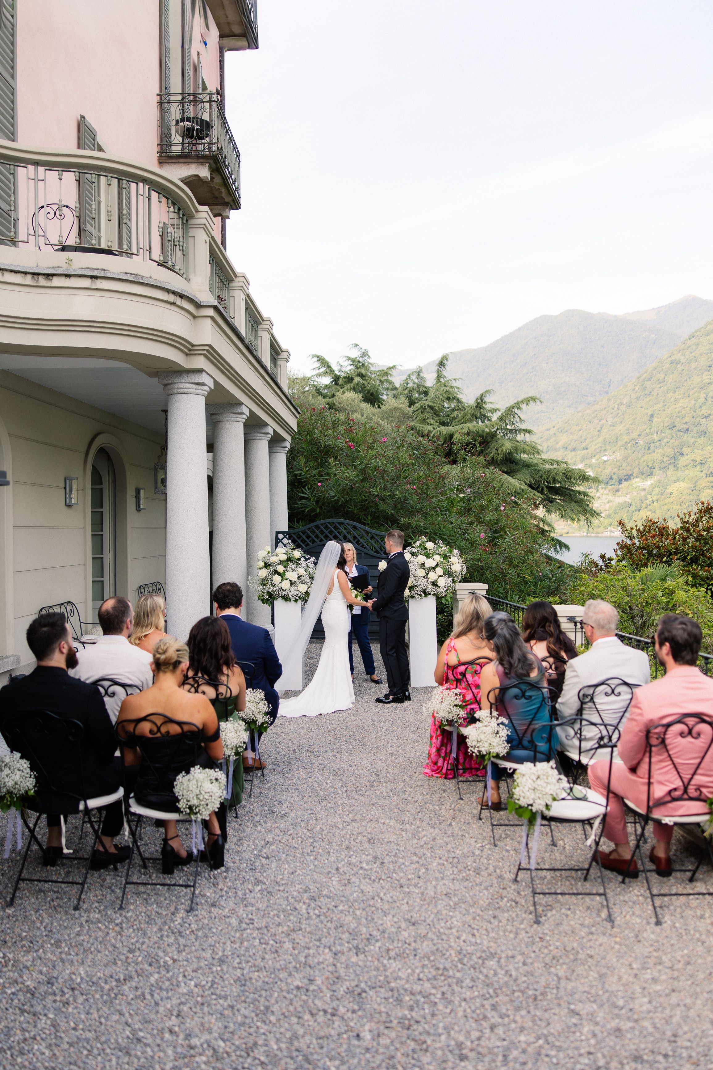 Couple exchanging vows in a lakeside courtyard during a small wedding in Italy