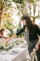Destination wedding planner lighting candles on a dinner table in Italy