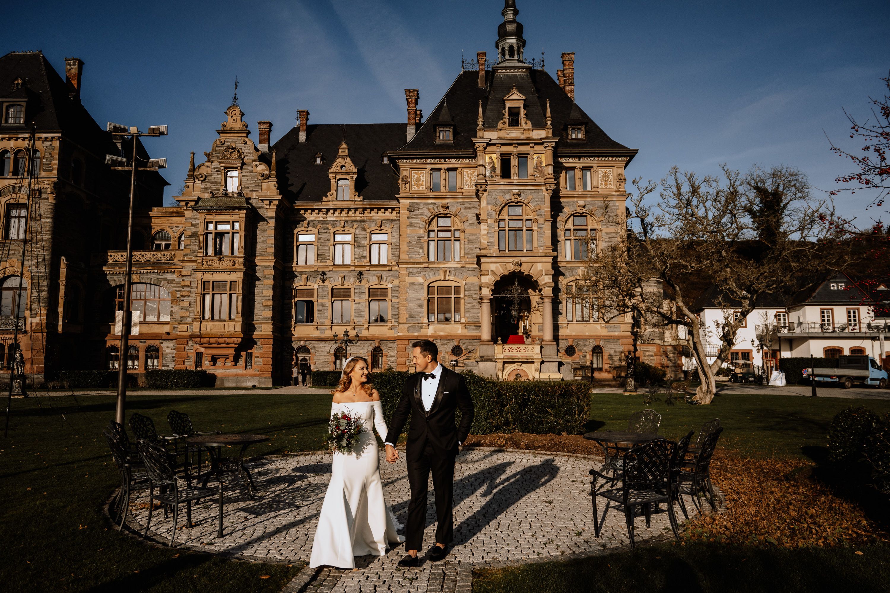 Bride and groom standing in front of a castle for their intimate wedding in Germany