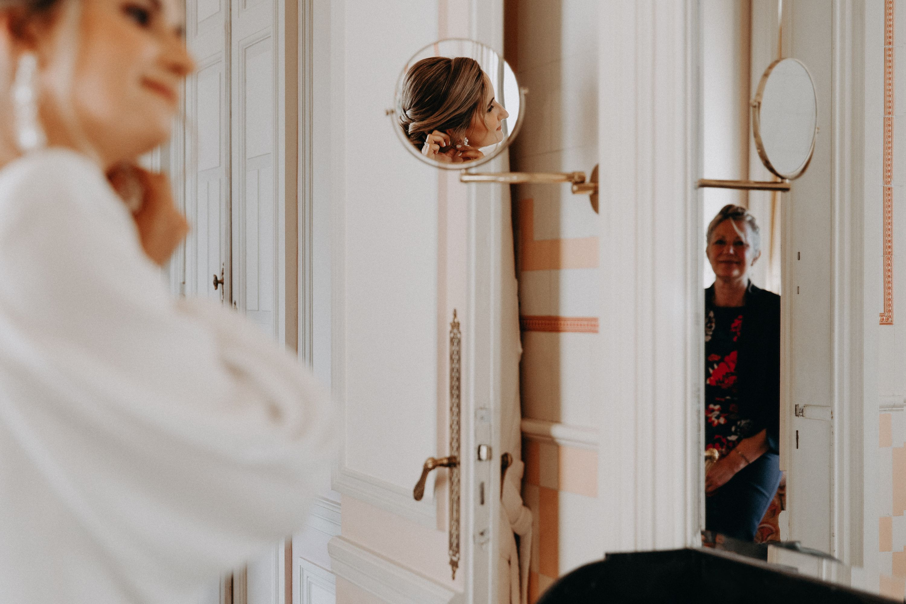 a bride getting ready in the morning and her mother watches happily