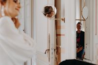 a bride getting ready in the morning and her mother watches happily
