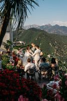 Bride and groom hold hands during the outdoor ceremony of their small wedding in Italy overlooking the mountains in Amalfi