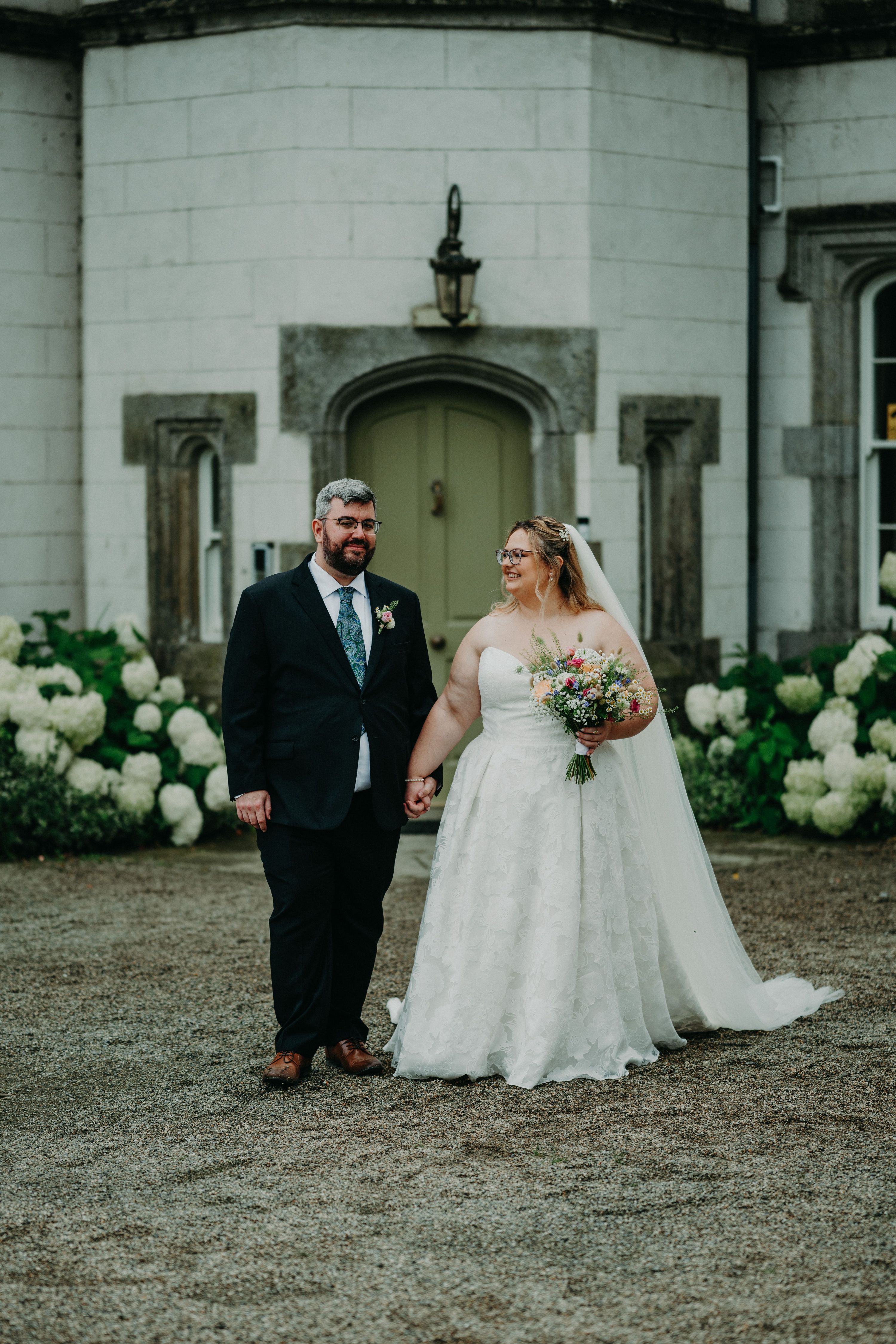Bride and groom having a photoshoot for their destination elopement in Ireland, with a white castle in the background