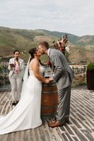 Bride and groom kiss during the ceremony of their small wedding in Portugal with the Douro valley in the background