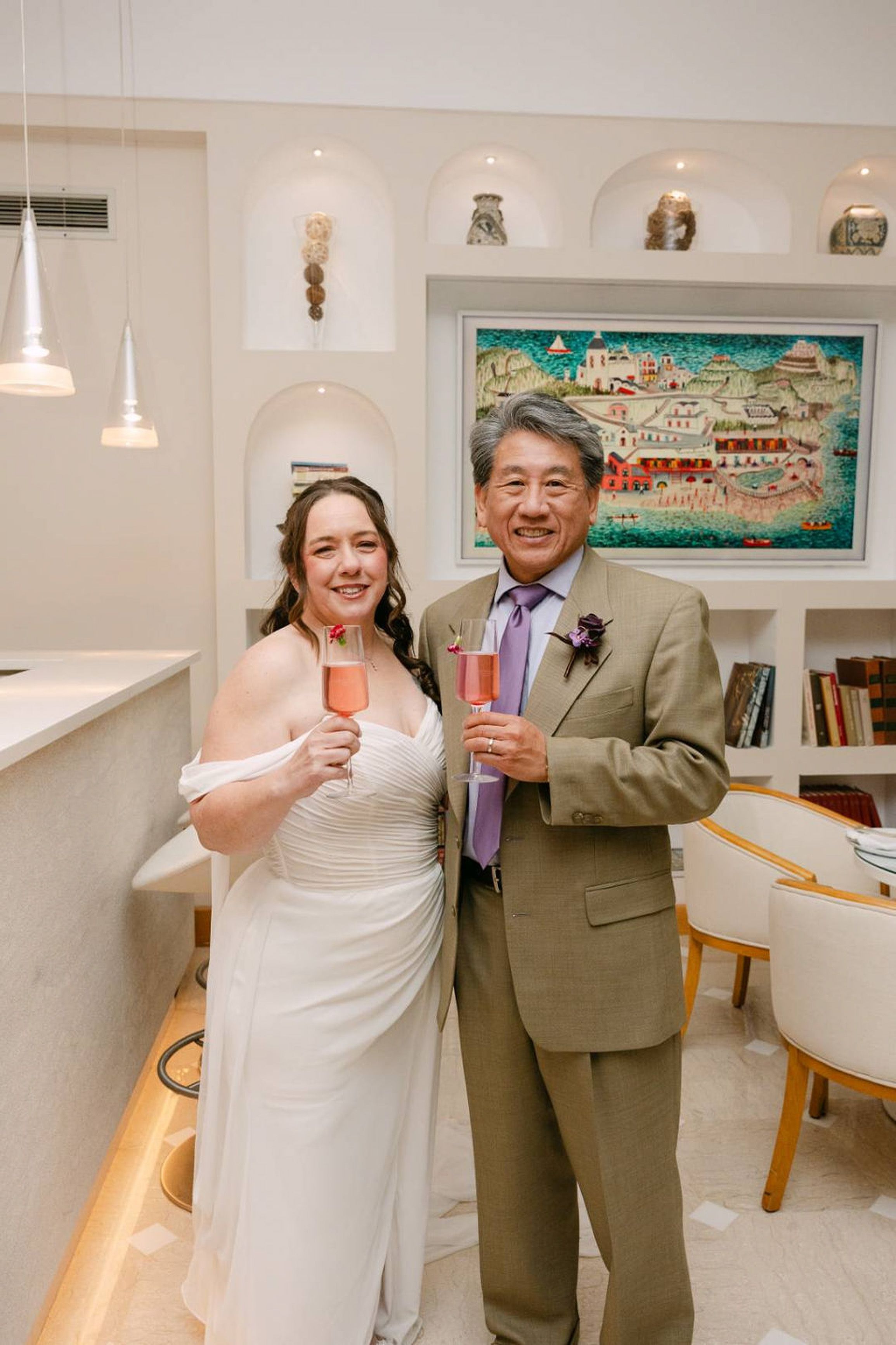 Couple raise sparkling rosé glasses in celebration after their small wedding in Italy