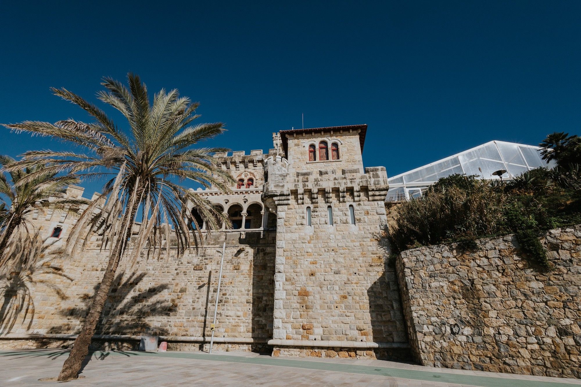 Brick-walled castle with a tree on the side and a while marquee on the other for destination weddings in Portugal