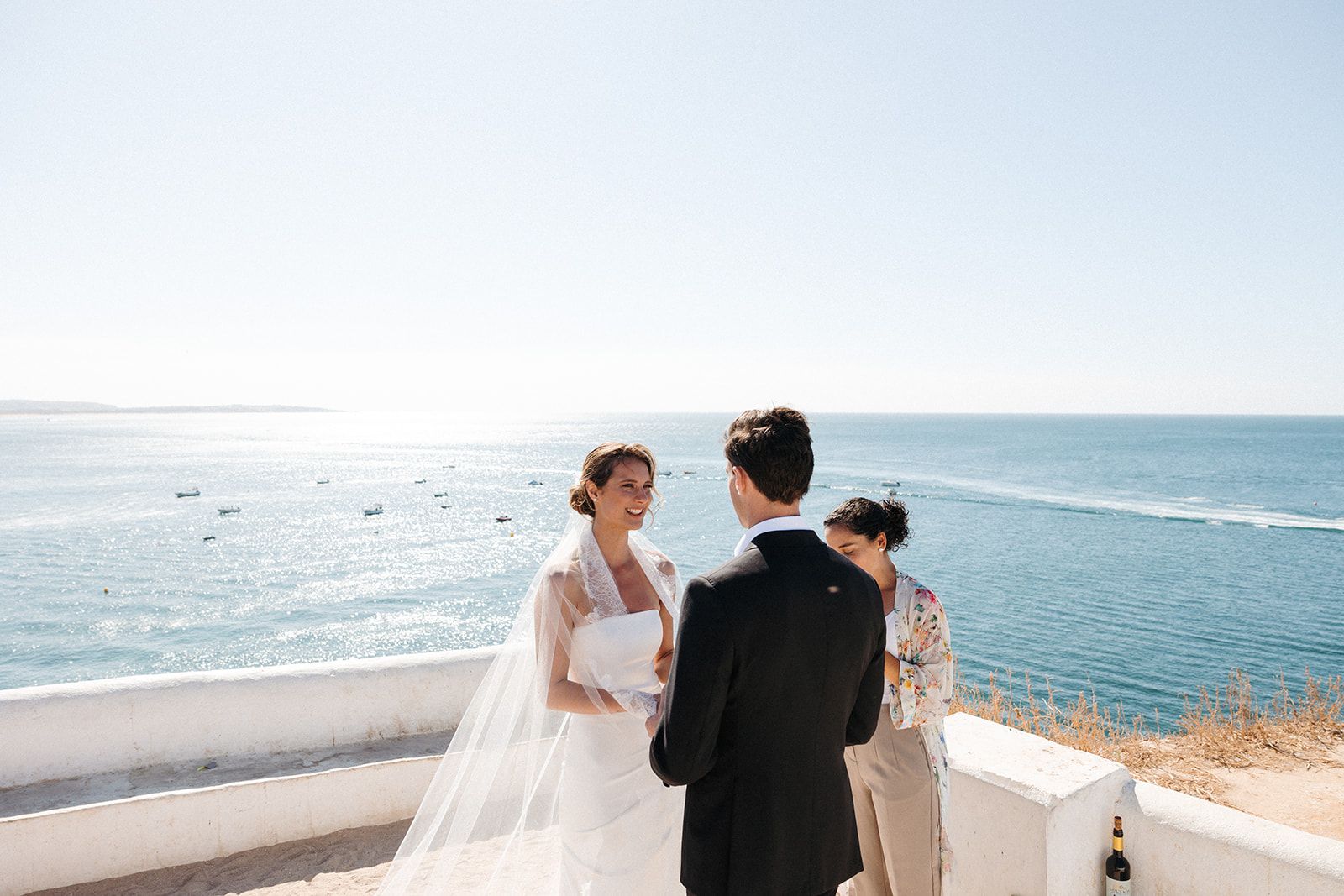 Bride and groom reciting vows atop a cliff with the Algarve coastline in the background