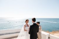 Bride and groom reciting vows atop a cliff with the Algarve coastline in the background