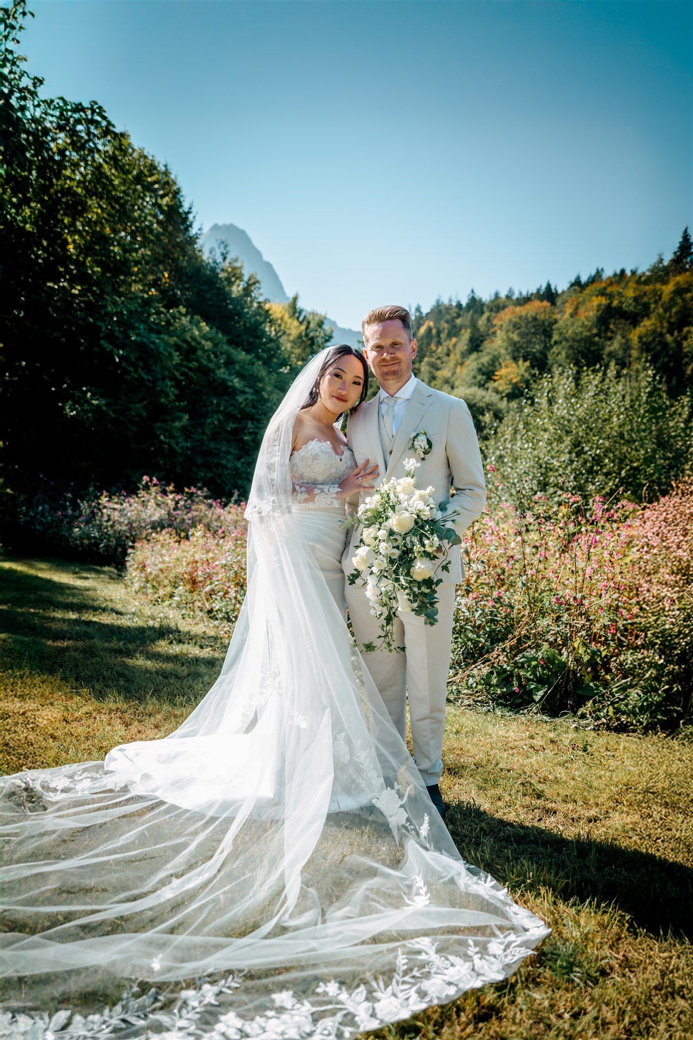 A bride and a groom with a lush forest and the alpine behind for their micro wedding in Germany