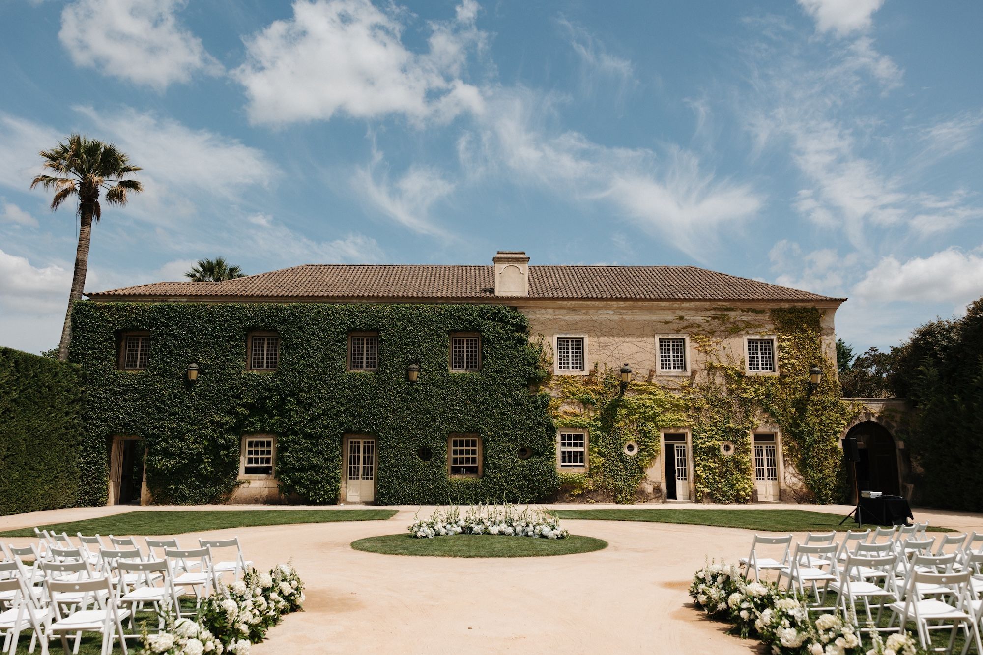 Ivy covered wedding venue in Portugal with the setup for a ceremony
