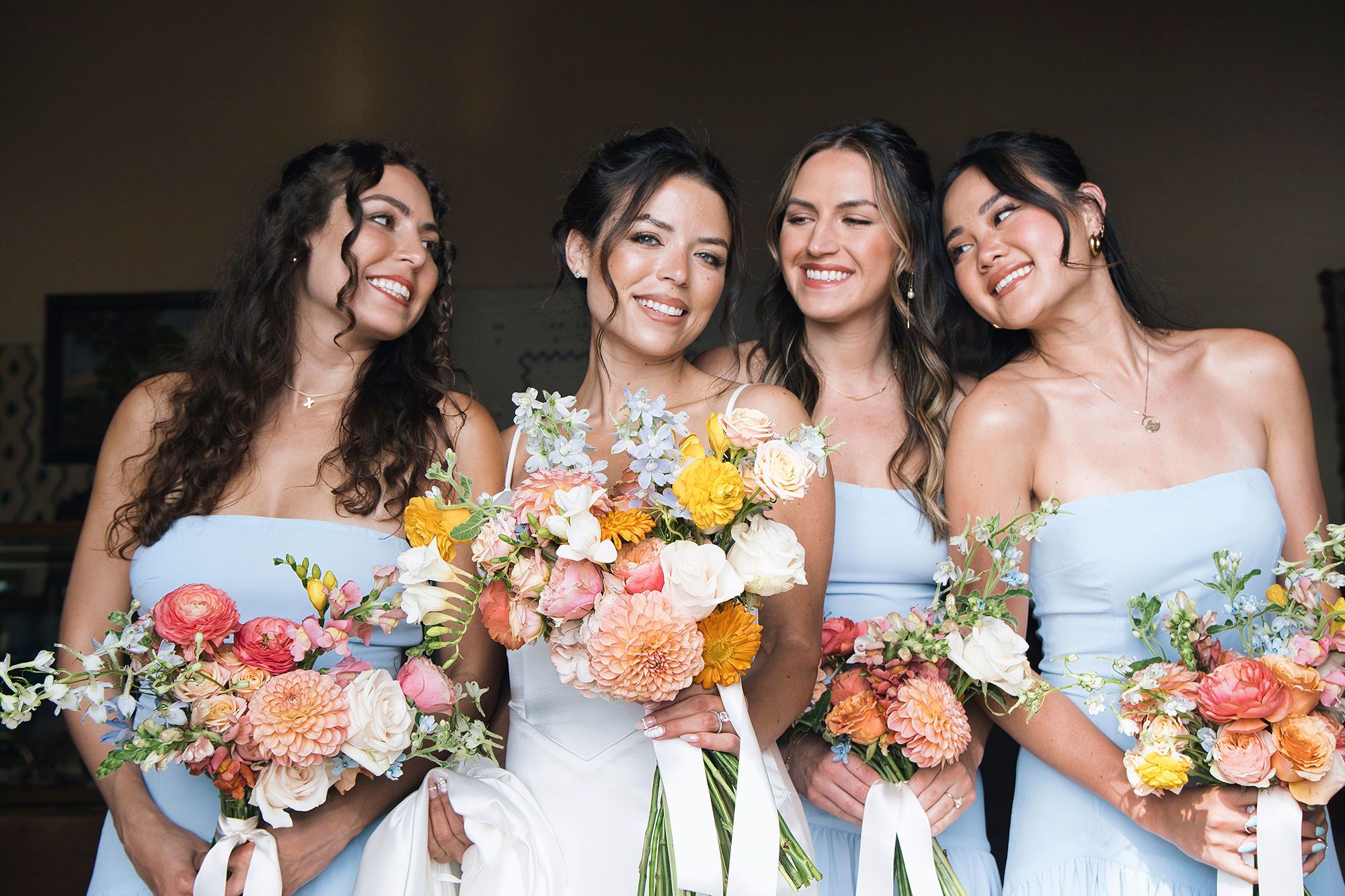 Bride with her bridesmaids holding bouquets during a destination wedding in Spain