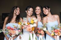 Bride with her bridesmaids holding bouquets during a destination wedding in Spain