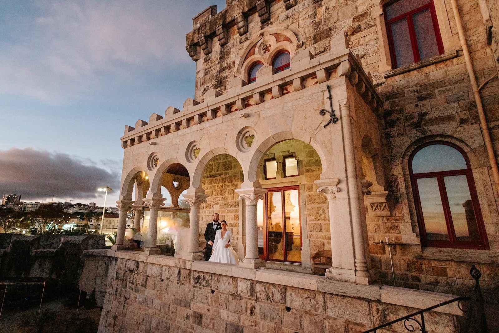 Newlyweds in the cloister of a castle in Cascais having a sunset photoshoot during their destination wedding in Portugal