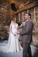 Groom looks at the guests while he and his bride smile during the ceremony of their small wedding in Spain