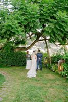 Bride and groom with their celebrant, having a garden ceremony on a hotel terrace with Amalfi Coast in the background
