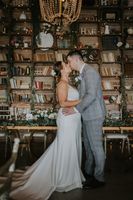 newlyweds kiss in a rustic event room during the reception of their intimate wedding in Portugal