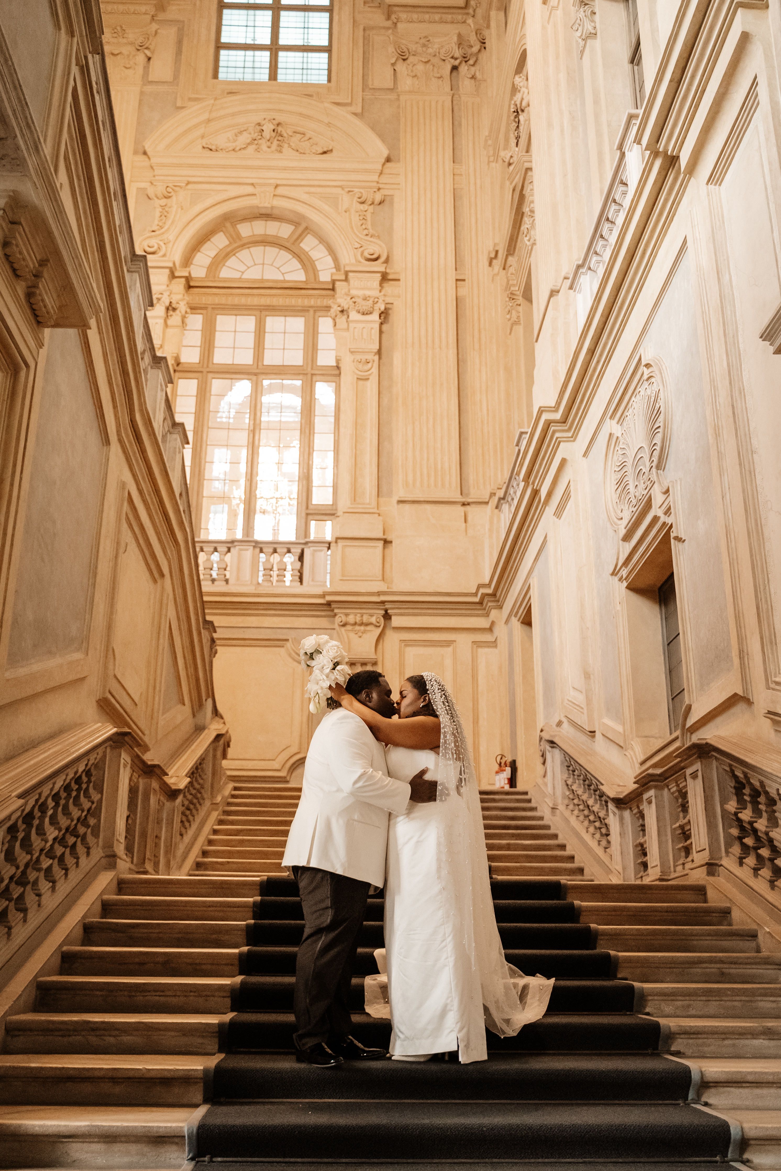 Bride and groom kissing each other at the iconic stairs of the museum where they got married in Italy