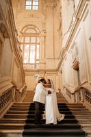Bride and groom kissing each other at the iconic stairs of the museum where they got married in Italy